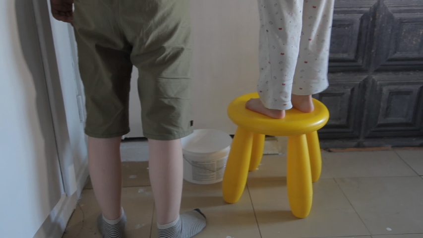 children brother and sister paint the wall with brushes and paint