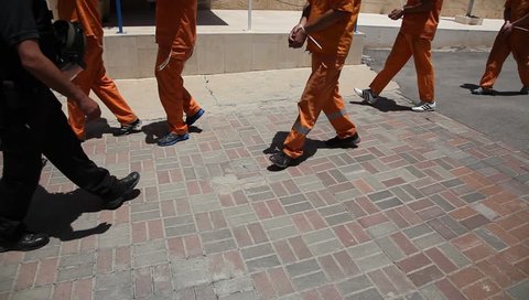 Policemen and inmates walk in prison.