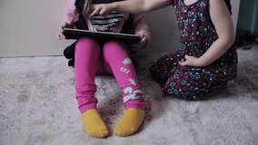 Funny child sitting on floor and using electronic devices.
