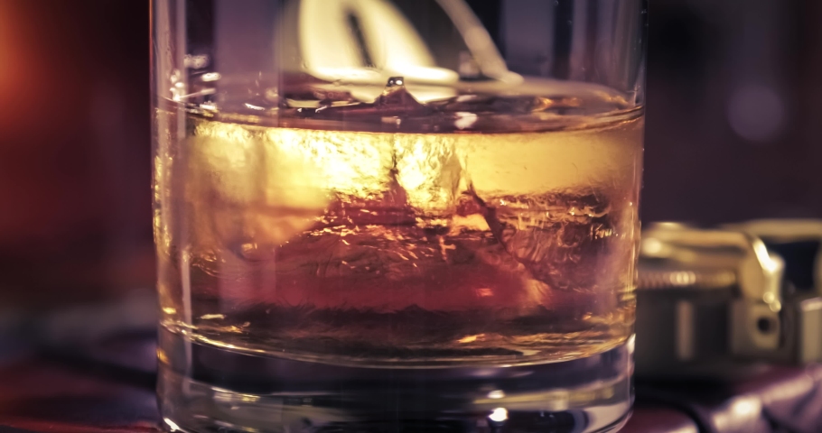 Melting cold ice and whisky in the glass on old diary | Shutterstock HD Video #1030581449