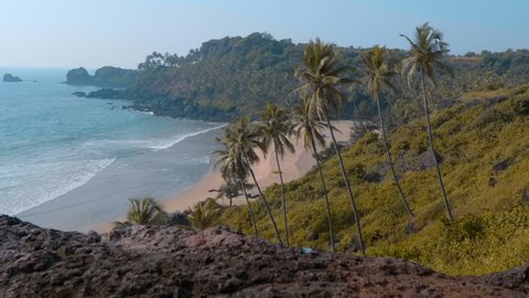 Amazing landscape - mountains overgrown with palm trees, a beautiful blue ocean and a wild beach between them, the dream of any tourist, Goa, India
