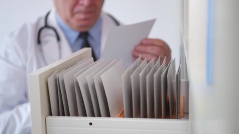 Doctor Open a Drawer and Looking for Documents in Hospital Medical Archive