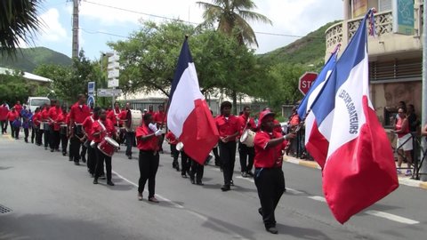 Marigot, Saint Martin - July 14 2013: Creole band with Red Shirts and Drums at Parade on the 14th July, the French National Holiday in Marigot. Afro-Caribbean Musicians celebrating Bastille Day.
