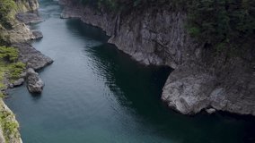 Aerial Pan Up of Gorge Cliffs and Emerald Water