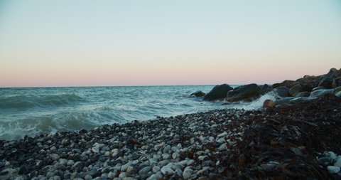 Stone beach and waves in sunse - footage is delivered in rec.709 - ready for color grade or LUT.