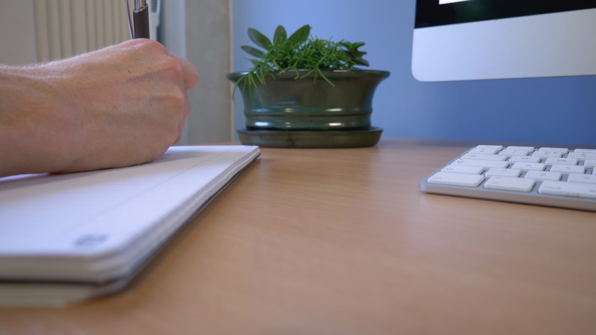 Office Worker Making Notes On Notepad