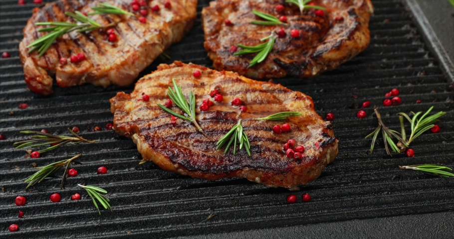 Grilling pork steaks, pork neck with the addition of herbs and spices on the grill plate, top view, 4k. Grilled meat, bbq, barbecue Royalty-Free Stock Footage #1030608839