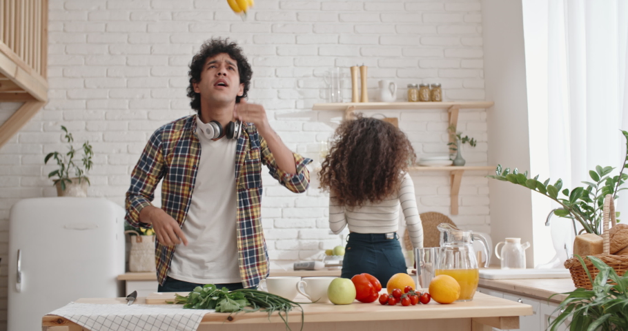 Young joyful couple spending time together cooking. Asian people dancing and singing while cooking at kitchen - recreational pursuit concept 4k Royalty-Free Stock Footage #1030633409