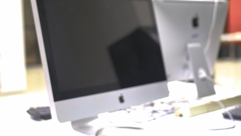 Samut Prakan, Thailand - June, 2019: 4K Dolly in close up shot of Apple Inc. logo on iMac computer on a table in the office
