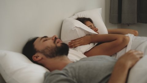 Couple with snoring problem concept, Woman has problem form her husband snoring while sleeping on bed