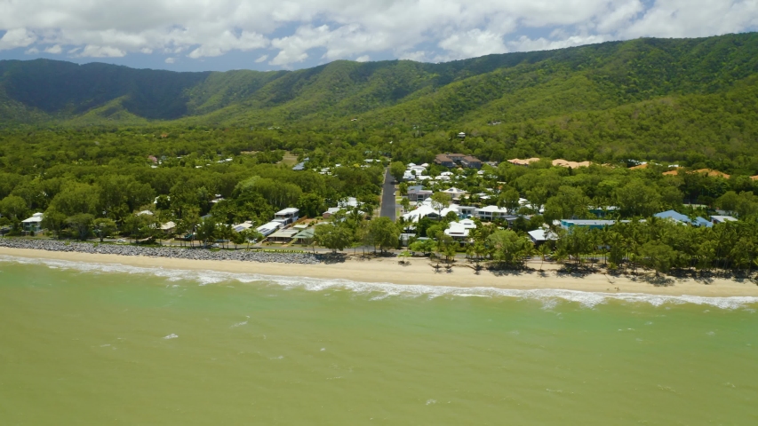 Aerial, beautiful view on the oceanside and a little suburban town on a large tropical beach in Cairns, Queensland in Australia
