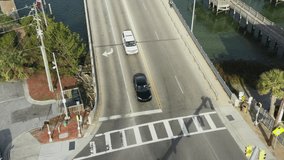 Tesla Entering Traffic Light Intersection Turning into Parking Lot at Wrightsville Beach North Carolina to Park Drone Shot