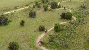Aerial clip of two bikers riding with their mountain bikes in a narrow path in the area of Wanaka, Otago, New Zealand.