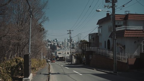 Downhill street which overlooks Sapporo city on sunny day - Hokkaid, Japan - Moving Shot