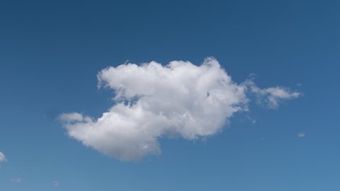 Time lapse of a white fluffy cloud isolated over a blue sky, 6K resolution video background