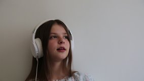 Teen girl is listening to music on headphones