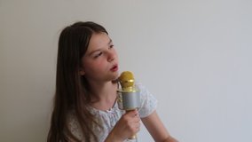 Teen girl is listening to music and singing with microphone