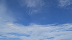 Sunny blue sky background with natural white Cirrostratus or Cirrocumulus clouds formation slowly building, moving & flying TimeLapse. Puffy & fluffy cloud in tropical summer clear sky on sunshine day