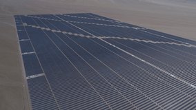 Aerial footage. Solar Energy Farm at Atacama Desert, Chile. Thousands modules rows passed on a reverse flight along the Solar Energy PV Plant an amazing scene from an aerial drone point of view 1/2