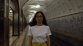 A girl of Asian appearance. In the subway close-up face of a girl with glasses.