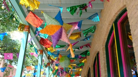 Pinatas and papel picado hanged outside during fiesta time. Mexican celebration background
 