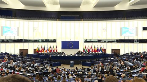 Strasbourg, France - Circa 2018: People inside hemicycle of European Parliament headquarter in Strasbourg with all Eu Members flags on the tribune and explanation about how parliament works
