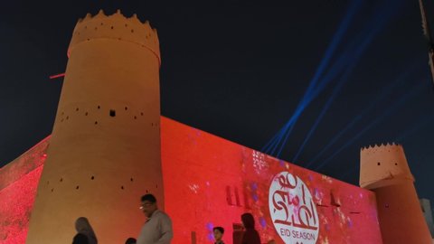 RiyadhSaudi Arabia - June 4, 2019: A family walks past the Al Masmak castle in the capital of KSA projected with light show for Eid Season. Vídeo Editorial Stock