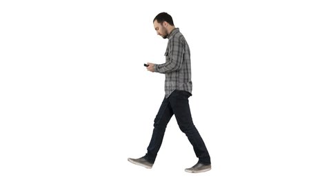 Young bearded man walking and talking on the mobile phone on white background.