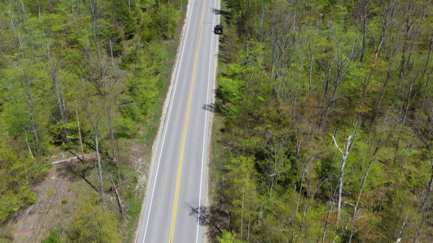 Aerial overhead view of curve asphalt road in the green forest, Wisconsin, Door County