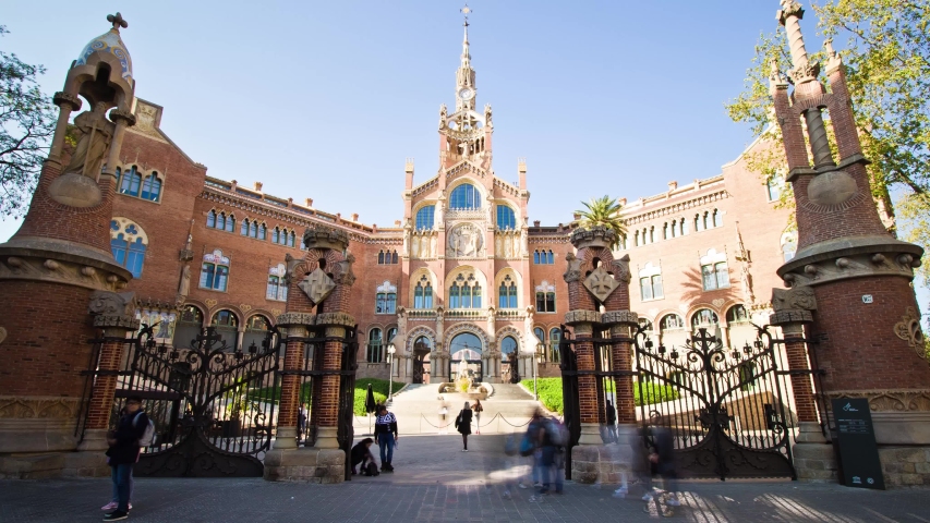 Barcelona, Spain - March 29, 2019: Hyperlapse (timelapse) approaching the facade of the Hospital de Sant Pau, a modernist building designed by Lluís Domènech i Montaner, finished in 1930.