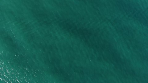 Aerial top down view from high altitude of green sea water texture. The camera flies over the water, a view of the water surface. Background of the water surface. 4K aerial view Arkivvideo