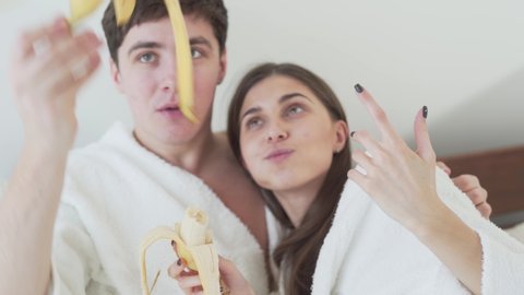 Couple Finish Eating And Sharing A Banana In Bed Sitting Up