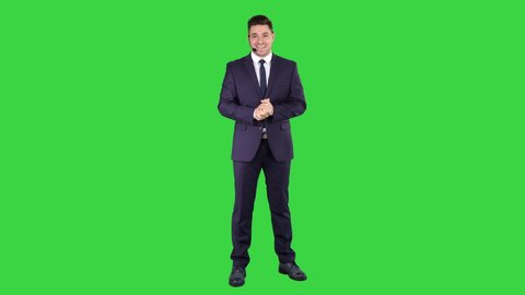 Man in formal clother with a headset presenting something on a Green Screen, Chroma Key.: stockvideo
