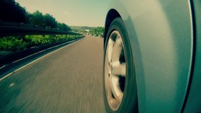 A highly stylized clip of a car speeding down the highway on the German autobahn. Highway wheel fuji film grade.
