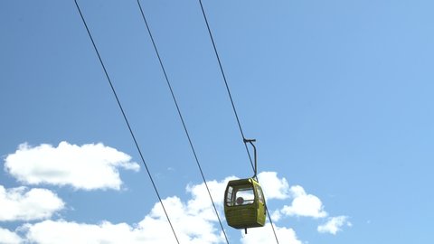 Cable cars moving up and down, with blue sky and clouds as a background. Liming, Yunnan. 