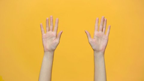 Woman hands waving, dancing snaps her fingers to music rhythm gesture isolated over yellow background in studio. Copy space for advertisement. With place for text or image. Advertising area, mock up.