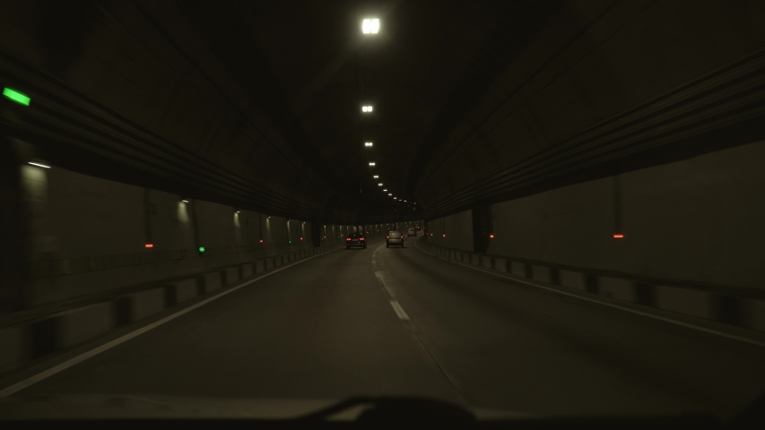 View from the car passing through the tunnel. The car passes through a long tunnel in the mountain Royalty-Free Stock Footage #1030763771