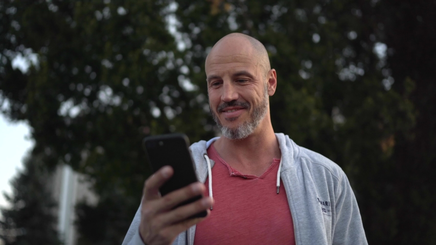 Man smiling and looking into mobile phone