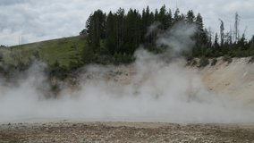 Close up steady shot of steam rising from the mud volcano area at Yellowstone National Park in Wyoming.