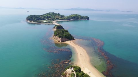 Flying under sunny sky over the Angel Road, a tidal sandbar (shoal) connecting 3 beautiful offshore islets to Shodoshima Island in Seto Inland Sea and a tourist attraction in Tonosho, Kagawa, japan