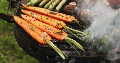 Grilling vegetables with the addition of spices and herbs on the grill plate outdoors. Vegan grilled food, 4k