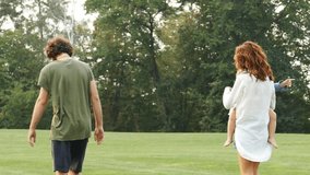 Happy family walking in the park together. Slow motion video.
