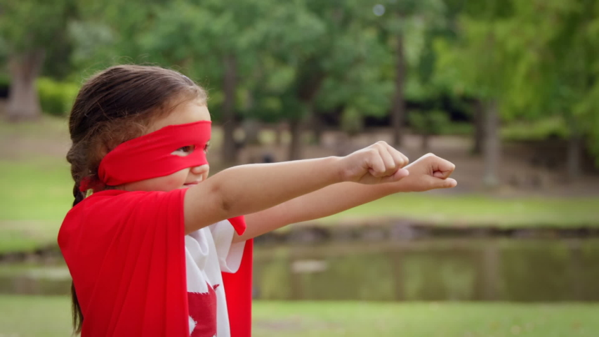 Side view of a little Caucasian girl pretending to fly at the park in a digital photo border effect