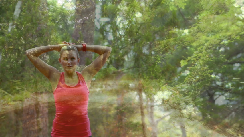 Digital composite of a Caucasian woman stretching in the woods with trees in the foreground