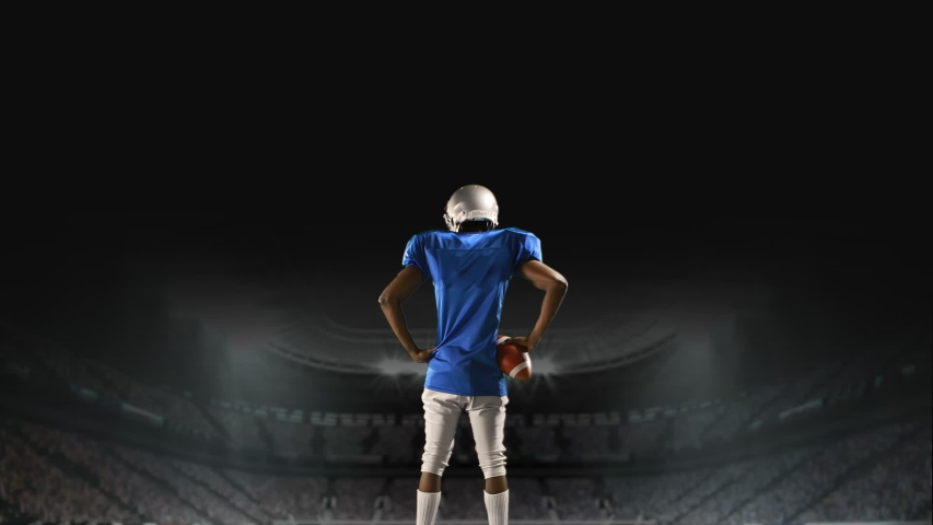 Digital composite of an African-american football player standing on a foggy field stadium