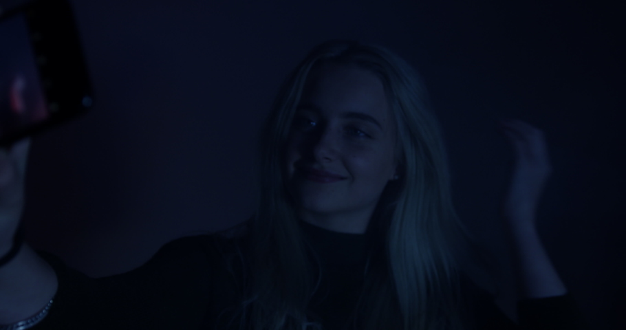 Portrait of Pretty Blonde Woman, Taking Pictures and Smiling At the Club in the Smoke and Flashing Red And Blue Lights. Beautiful Blonde Model Enjoying the Party. Colourful room