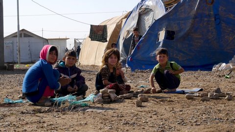 Erbil, Kurdistan / Iraq - 11 08 2018: Kurdistan Iraq refugee camp, November 2018 - children made homeless by ISIS play in the dirt
