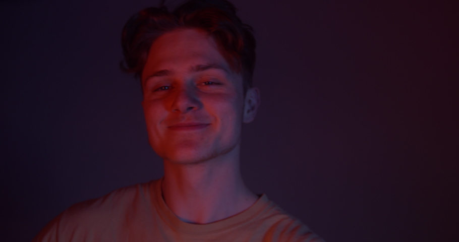 Slo-mo Handsome Young man Dancing and Smiling Care Free In the Blue and Red Lights With Smoke. At The Club On a Night Out