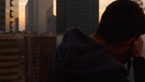 Cinematic video of a photographer taking pictures on the top of a roof in la defense, Paris at sunrise.
