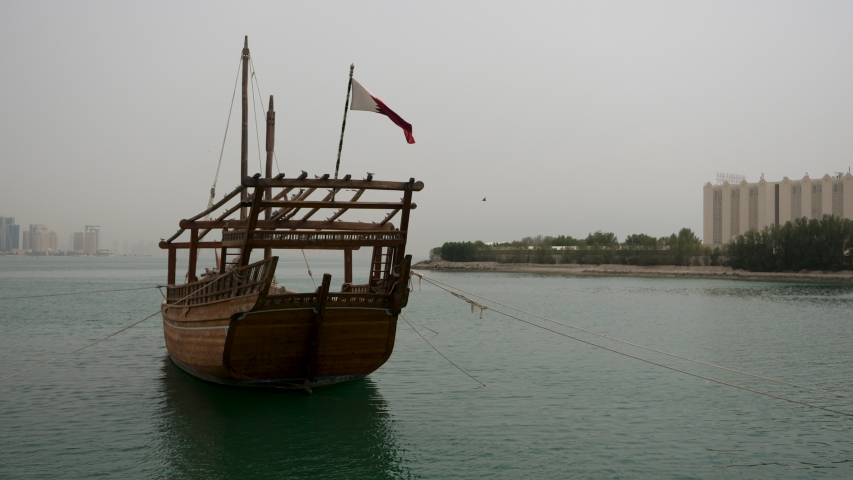 Old wooden dhow boat is slowly rocking in harbor of Doha Fishing boats Dhow in Doha Harbor  in Doha, Qatar, Middle East